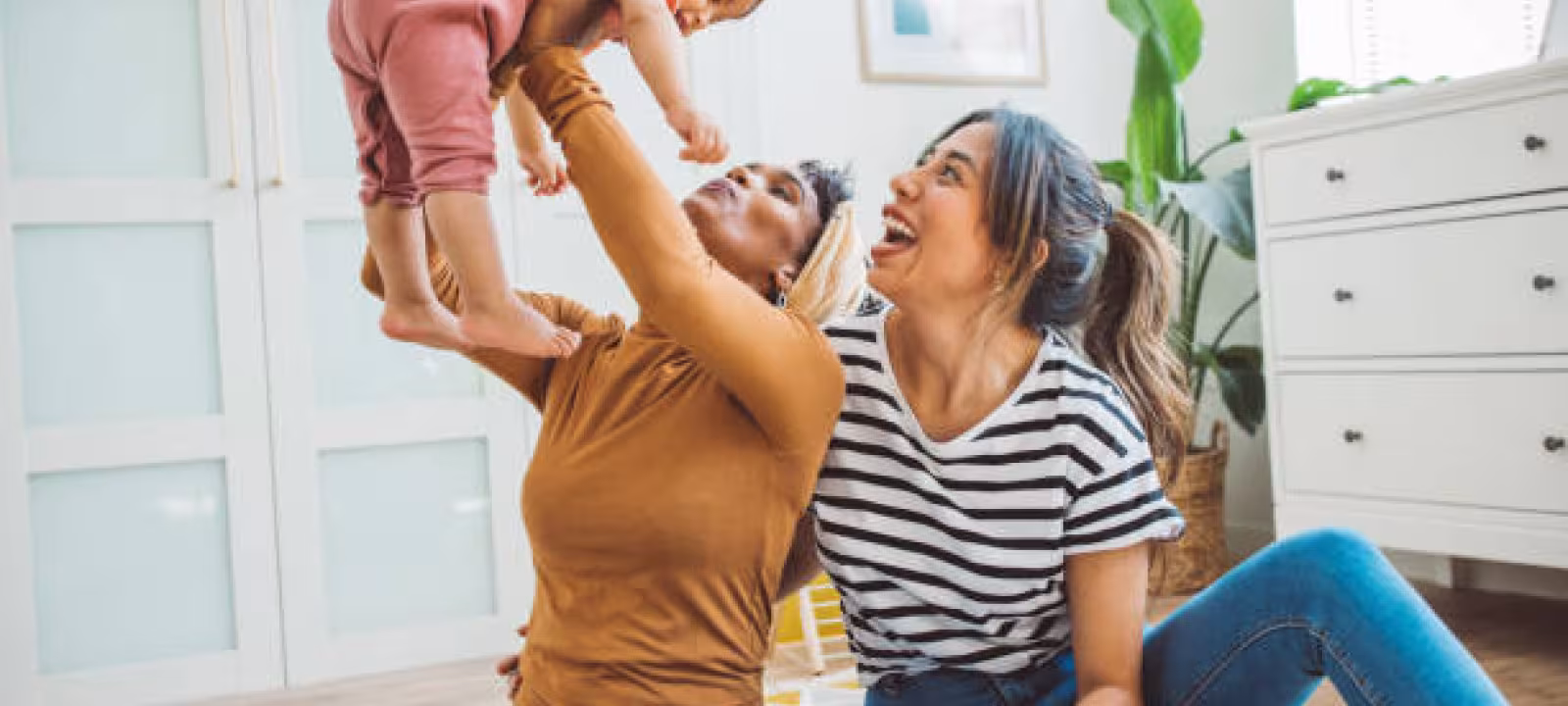 Two women holding a baby