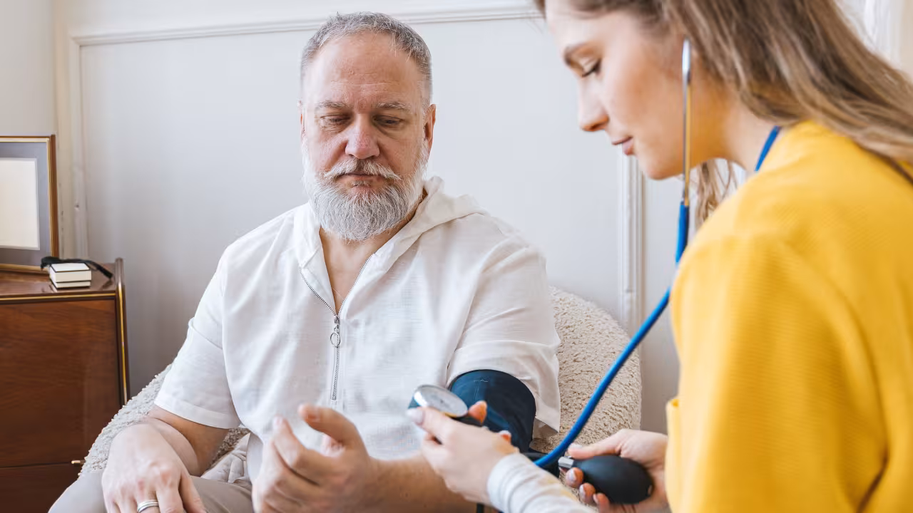 A nurse helping a patient in their home 